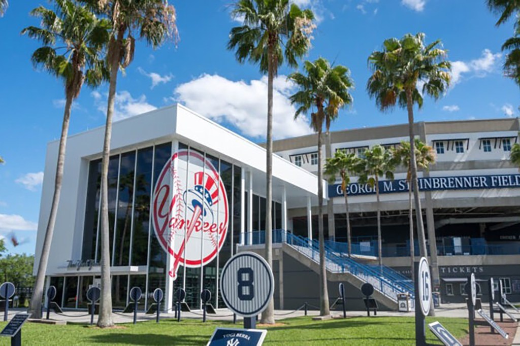 A building with a sign, surrounded by palm trees, likely associated with Yankees spring training